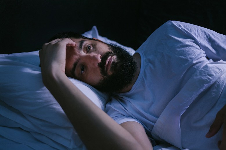 Man with sleep apnea in Edmonton, AB lying awake in bed